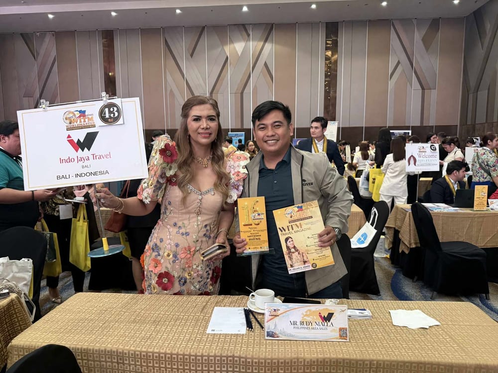 Indo Jaya Travel of Bali receiving a certificate of recognition at seller table 43, the plaque and a WITM Travel Magazine on the table.