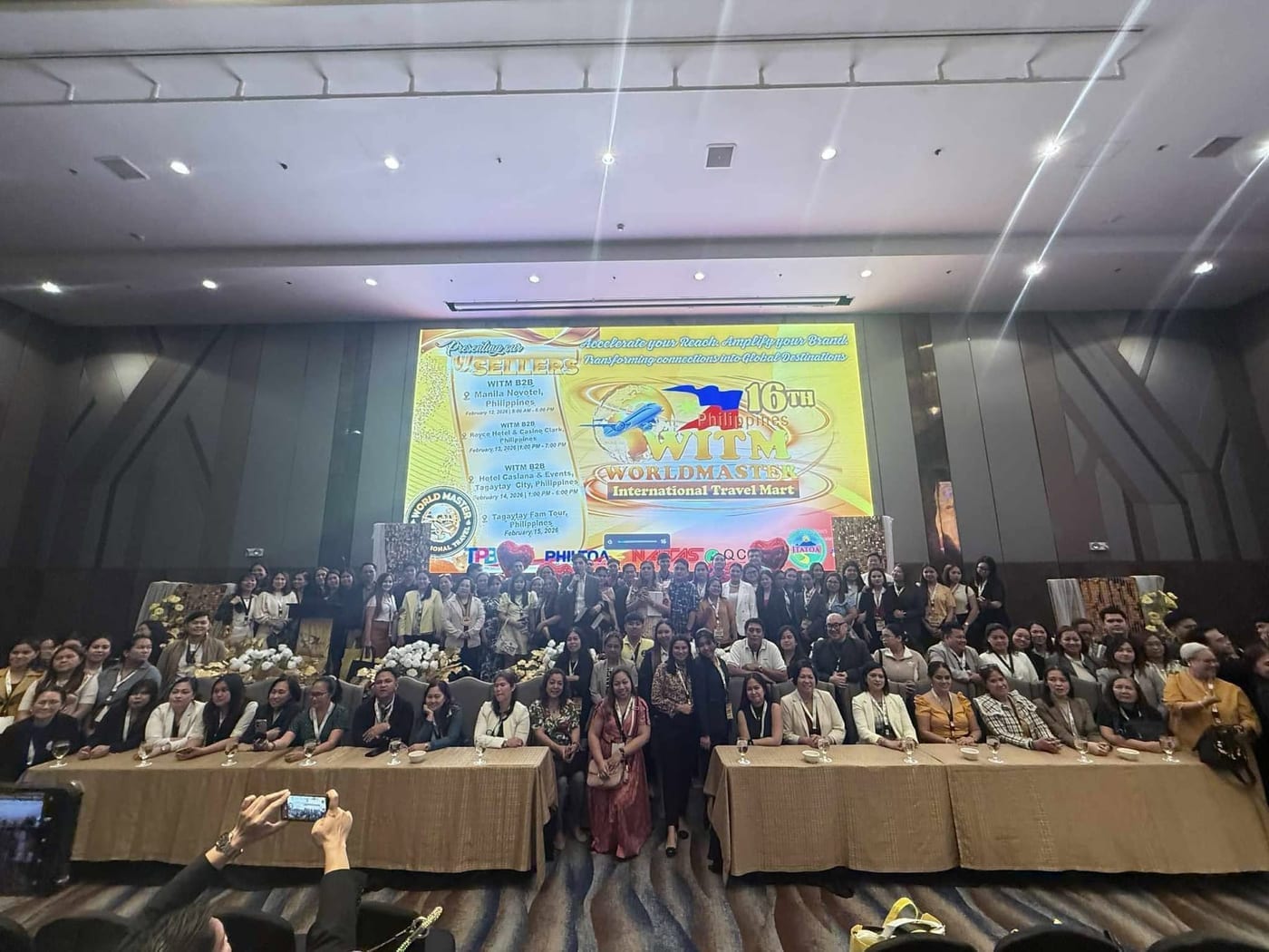 Opening ceremony of the 16th WITM in Manila: more than a hundred delegates and officials in front of the stage, the LED screen behind them carrying the 16th-edition logo and the full February 2026 schedule.